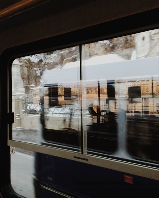 View of city buildings through a train window, showcasing the beauty of urban travel and architecture.