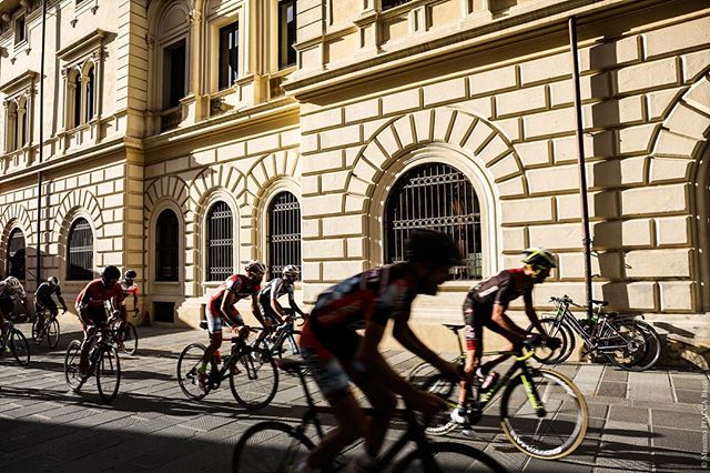 A group of cyclists racing on a city street, showcasing energy and movement.