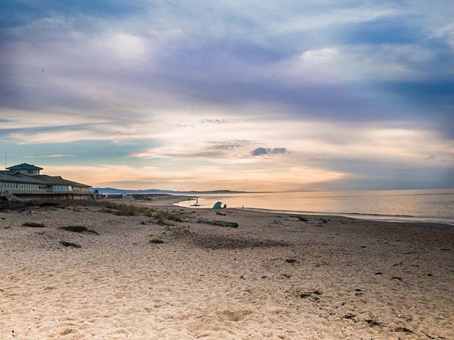 A tranquil beach scene with a calm ocean and dramatic cloudy sky at sunset. Perfect for travel or relaxation themes.