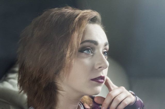 A woman gazes thoughtfully, a portrait with focus on her expression and soft lighting.