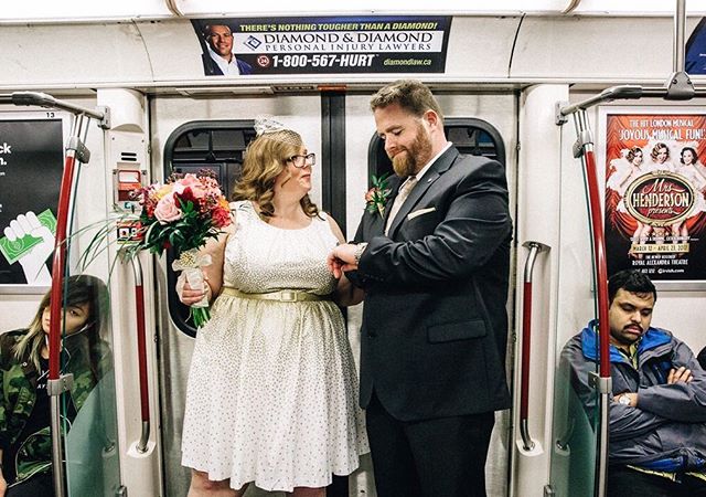 A bride and groom celebrate their wedding on a subway train with a few other passengers.