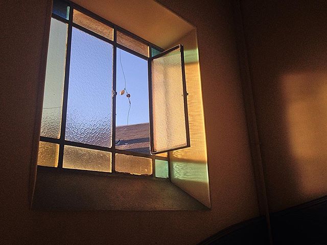 An open window with textured glass catches the soft light in an inviting indoor space.