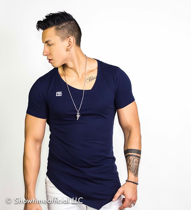 Athletic man in blue tee showcasing fitness and style against a clean white background.