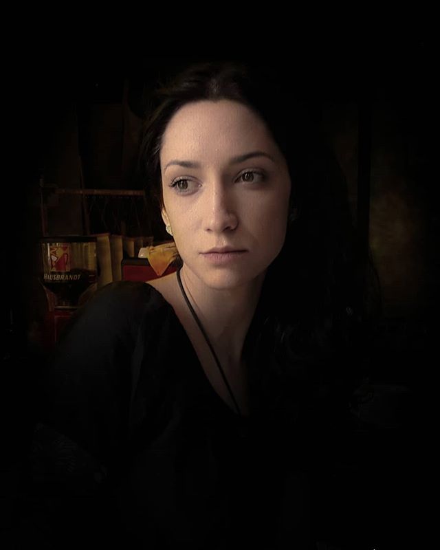 Intimate portrait of a brunette woman in soft light, with a contemplative and mysterious mood. 