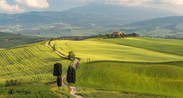 Scenic Tuscan landscape with rolling hills, a winding road, and a charming house. Perfect for travel and tourism content.