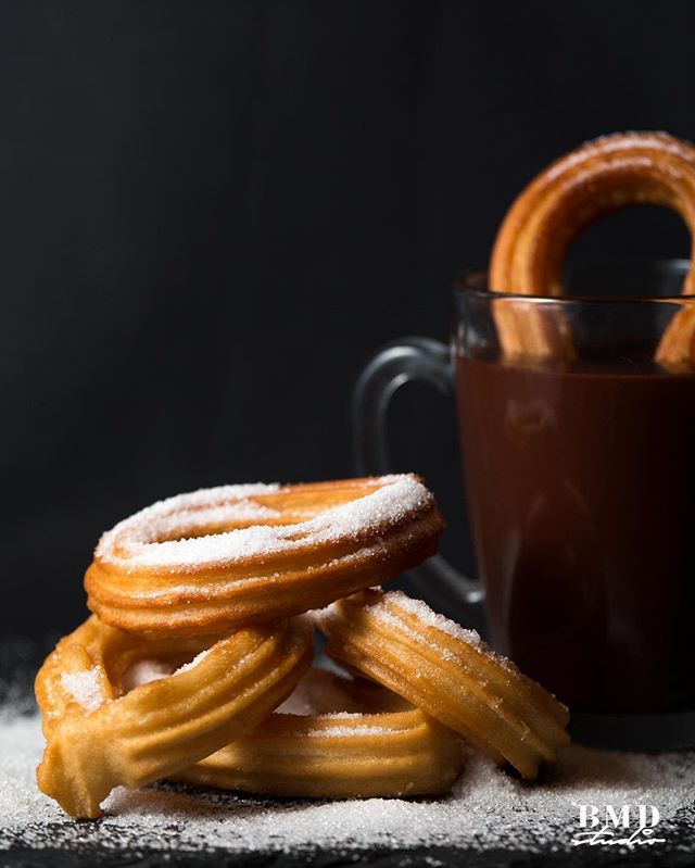 Delicious churros with sugar, served with hot chocolate. Perfect for a tasty dessert treat.