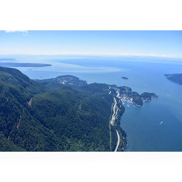 Aerial view of the coastline with forests, mountains and ocean in a serene and scenic landscape.