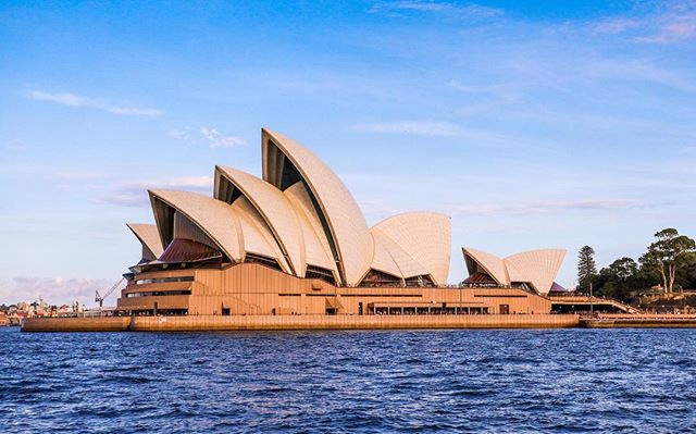 The Sydney Opera House stands majestically on the waterfront, a celebrated architectural icon in a vibrant cityscape.