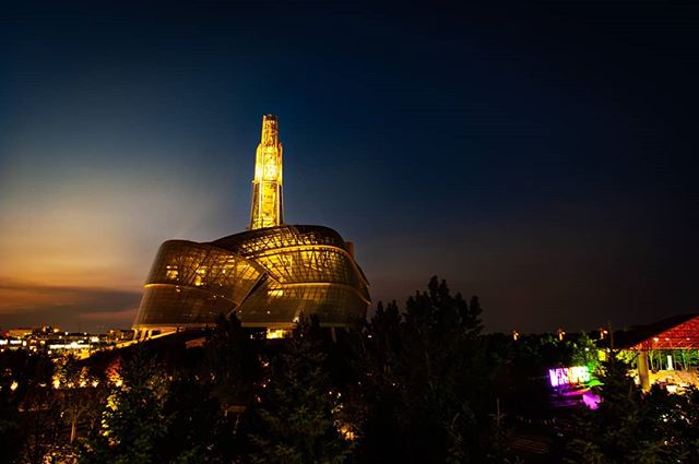 Illuminated building and tower at night, showcasing modern architecture and urban scenery.