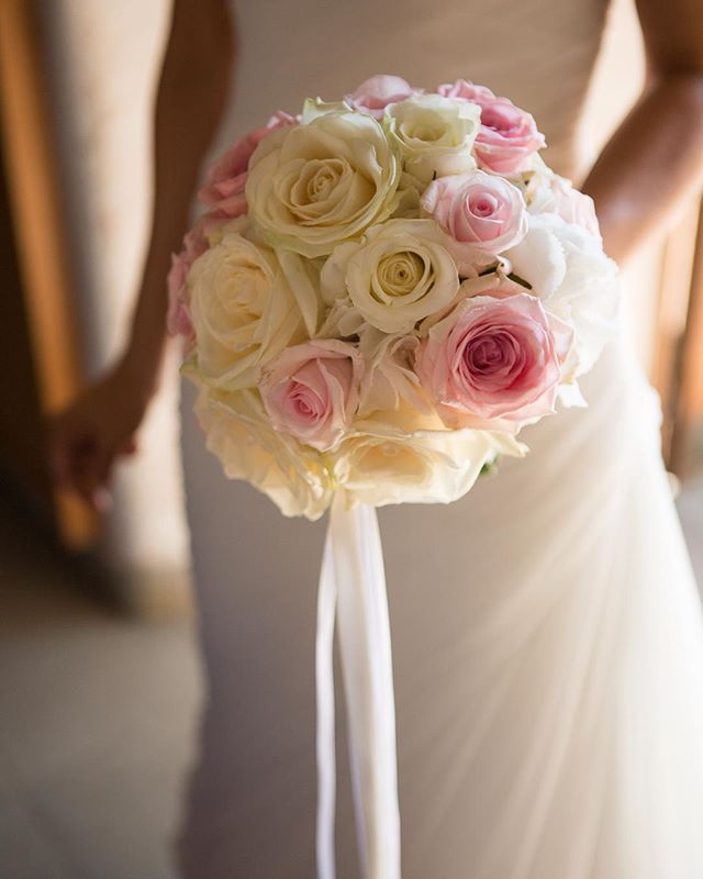 Bride holding a beautiful pink and white rose wedding bouquet.