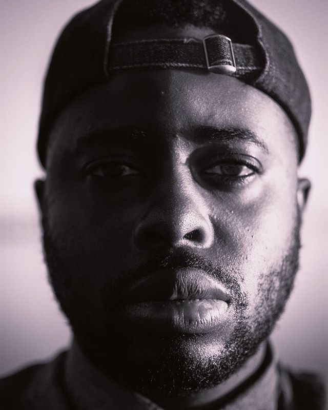 A striking black and white portrait of a confident African American man wearing a cap, ideal for executive branding.
