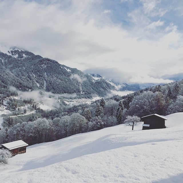 Snowy mountains and a small cabin create a tranquil winter scene, ideal for scenic travel and adventure themes.