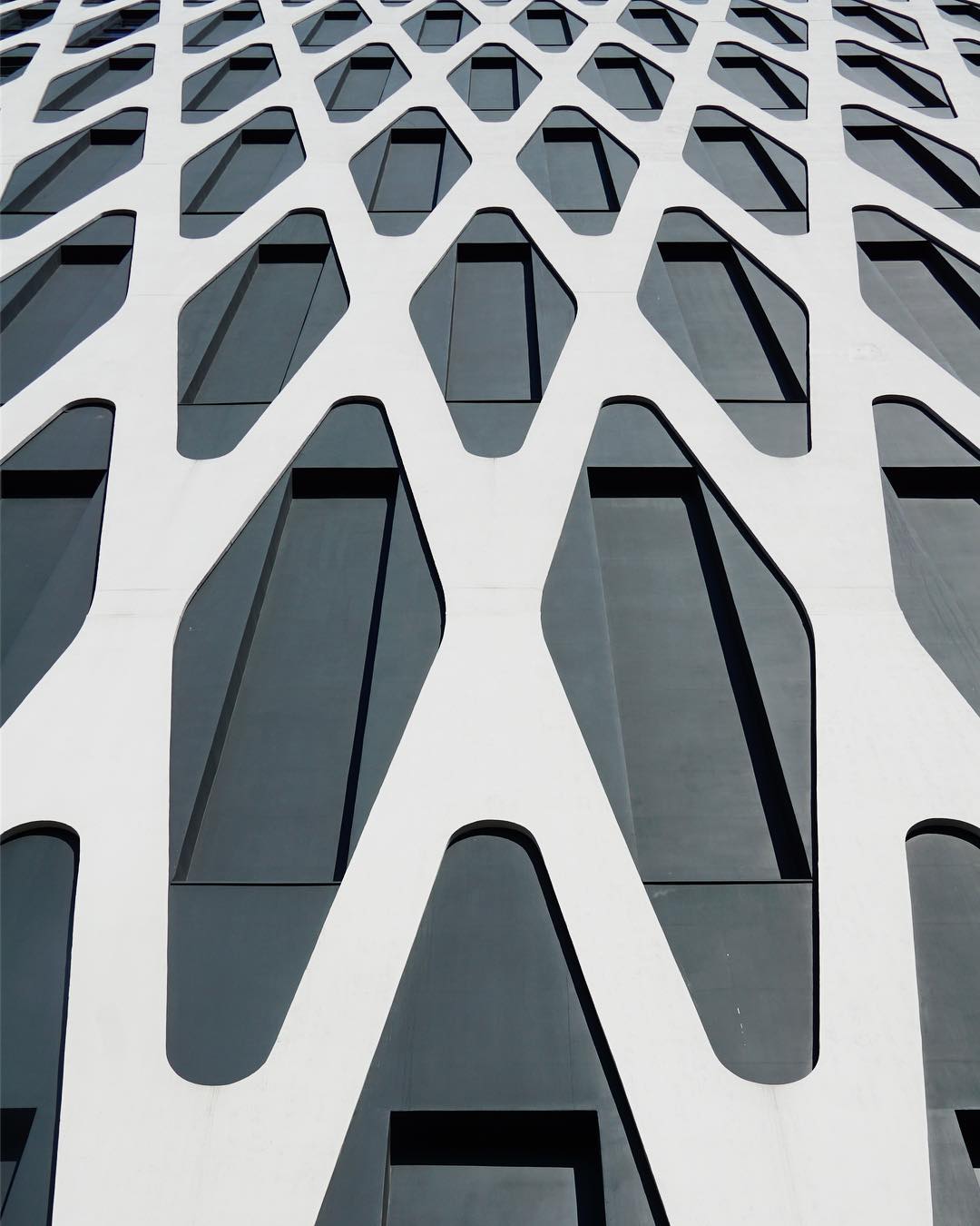 A modern building facade with geometric patterns and windows, creating a minimalist and abstract design.