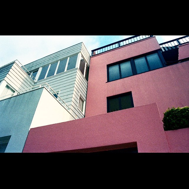 A unique low-angle perspective showcasing the modern architecture of colorful buildings against a bright sky.