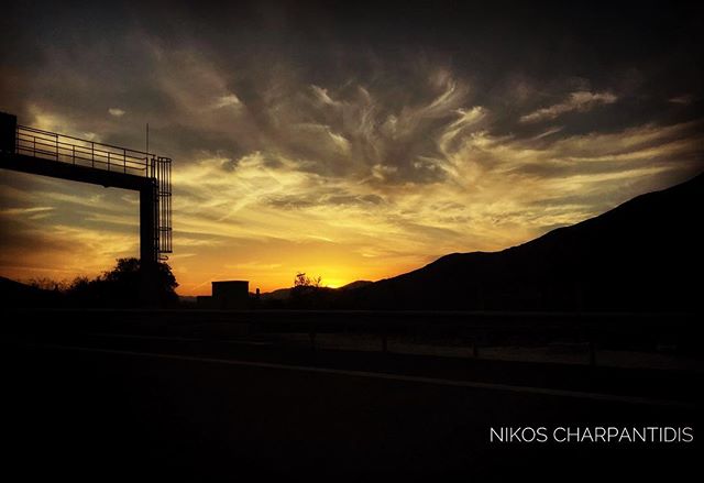 A scenic sunset over mountains with a silhouette bridge creates a tranquil and inspiring landscape.