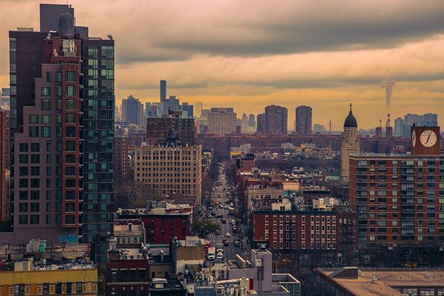 An expansive cityscape featuring buildings, skyscrapers and streets under a cloudy sky, showcasing urban living.