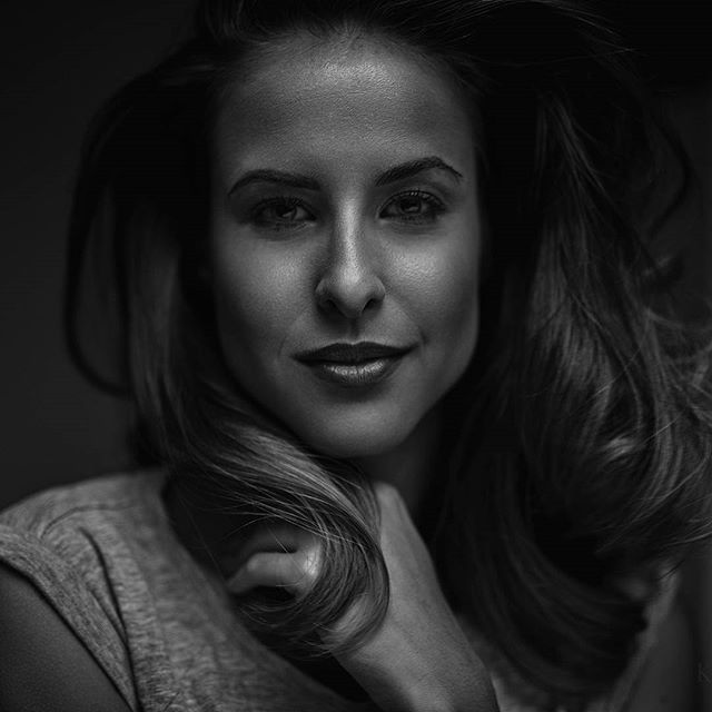Monochrome portrait of a confident woman in a studio setting, showcasing soft, flattering light.