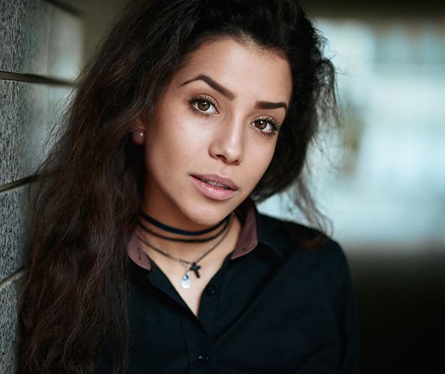 Portrait of a confident brunette woman with soft lighting and shallow depth of field.