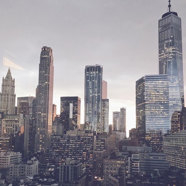 A cityscape view of New York City featuring modern skyscrapers against a soft, muted sky.