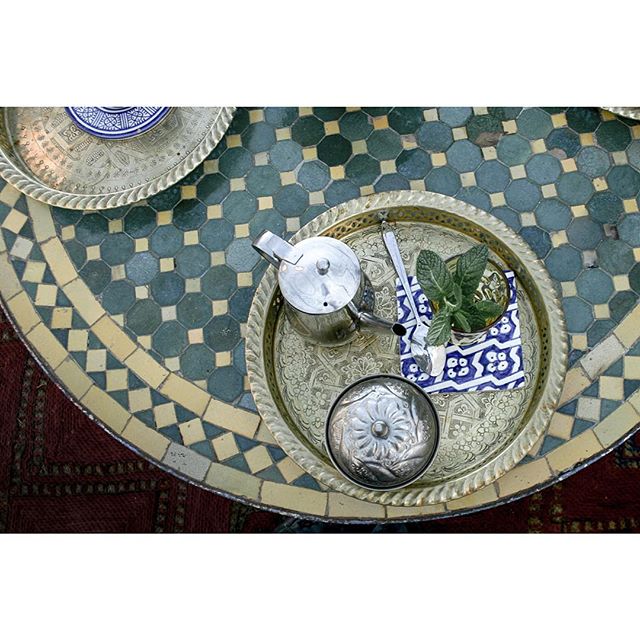 Overhead shot of a silver tea set with mint tea on a patterned table, perfect for a blog post or social media.