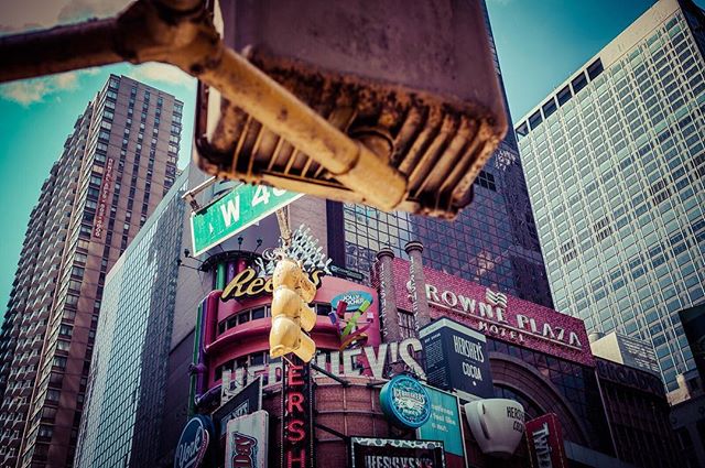 A vibrant view of Times Square in New York City, showcasing the iconic Hershey's sign and surrounding buildings.