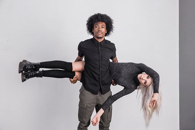 A man holds a woman in his arms in a modern, intimate studio shot promoting relationship marketing and fashion.