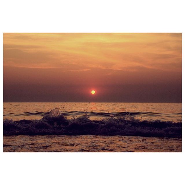 A serene sunset over the ocean, featuring soft waves and a warm, dreamy atmosphere.