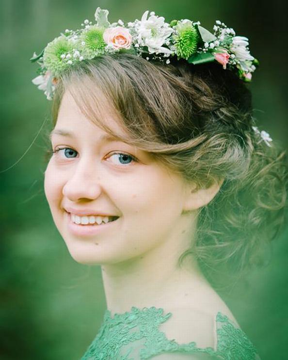 A young woman with a flower crown smiles softly in natural light, perfect for bridal or spring-themed content.