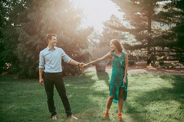 A young couple holds hands in a sun-dappled garden, evoking love and natural beauty.