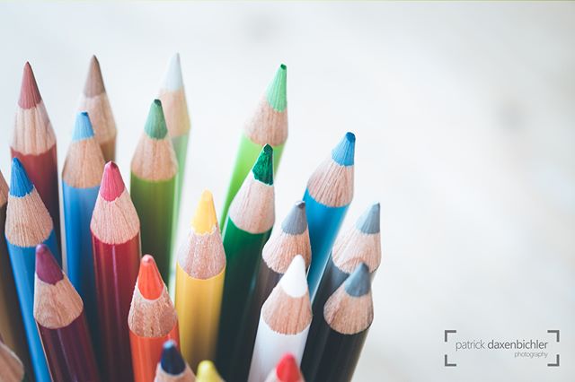 A close-up view shows colorful pencils with soft lighting and shallow depth of field, conveying a sense of creativity and art.