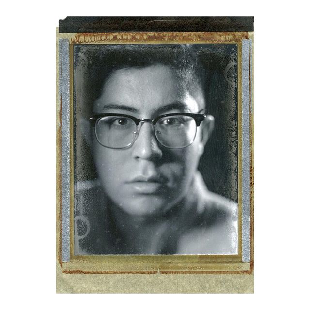 A vintage black and white portrait of a man wearing glasses, with a serious and thoughtful expression.