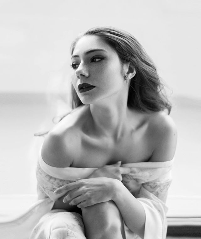 A beautiful woman poses in soft light for a sensual and intimate beauty editorial.