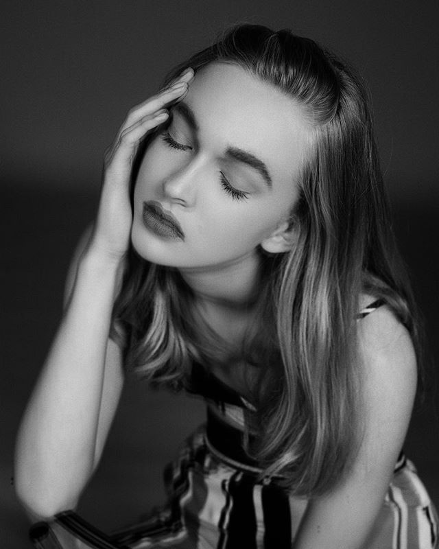 A monochrome portrait of a young woman with her eyes closed in a thoughtful pose. Perfect for editorial content.