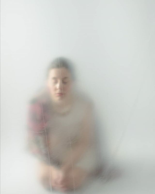 A serene woman sits in a meditative pose, exuding calm in a minimalist setting, perfect for wellness campaigns.