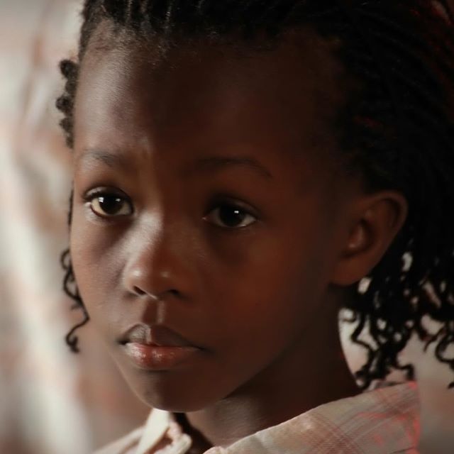 A close-up portrait of a young girl with a calm and serious expression.