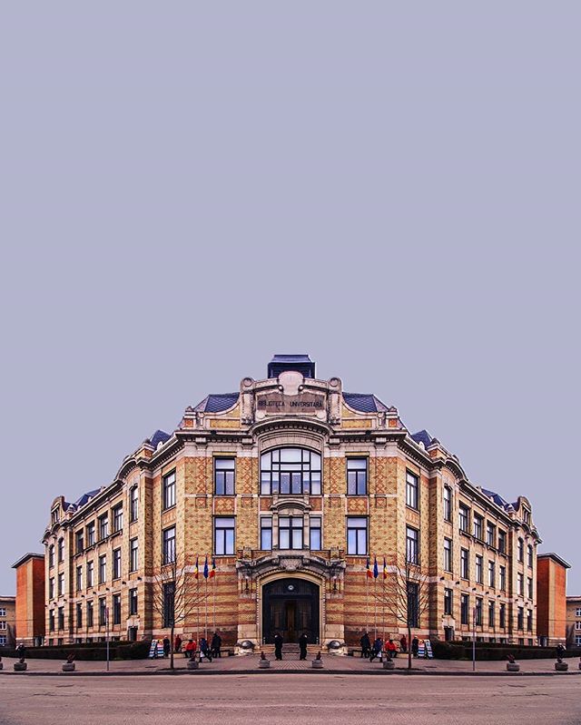 Symmetrical view of a classic brick university building with architectural details in a calm urban setting.