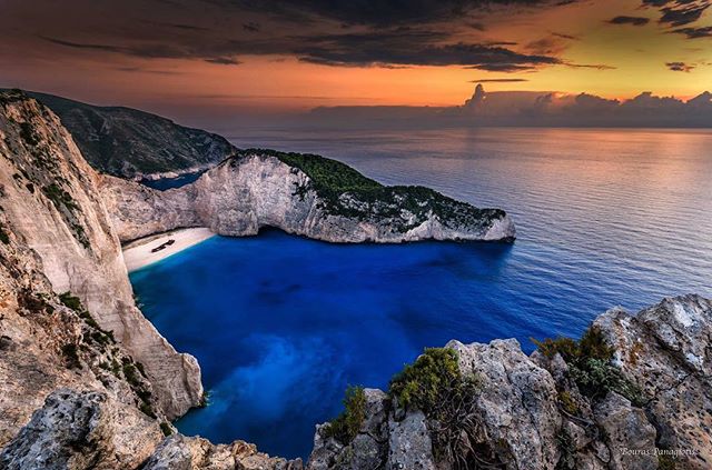 Scenic Navagio Beach bay on the coast of Zakynthos, Greece at sunset.