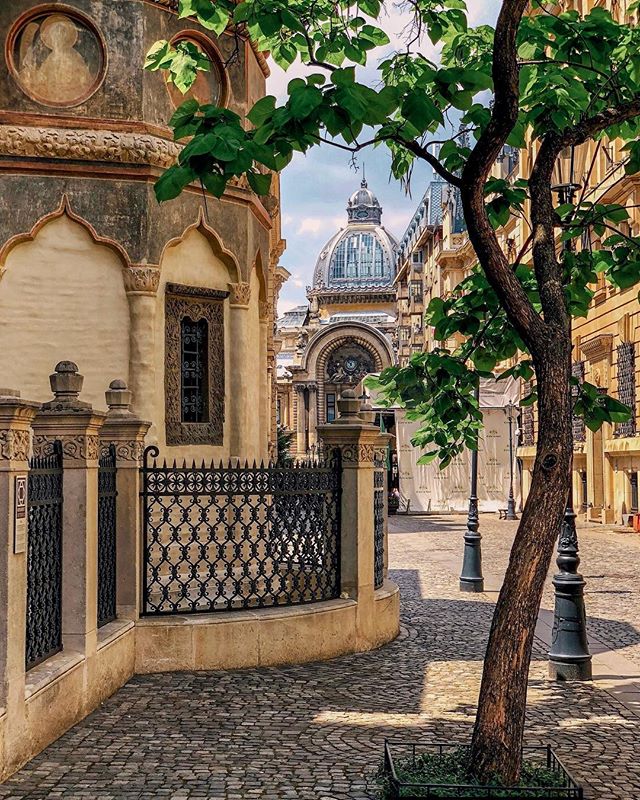 A tranquil street view featuring historical architecture and a prominent dome bathed in warm light in a European city.