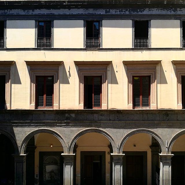 A classical building facade with arched columns and symmetrical windows offers a glimpse into historical architecture.