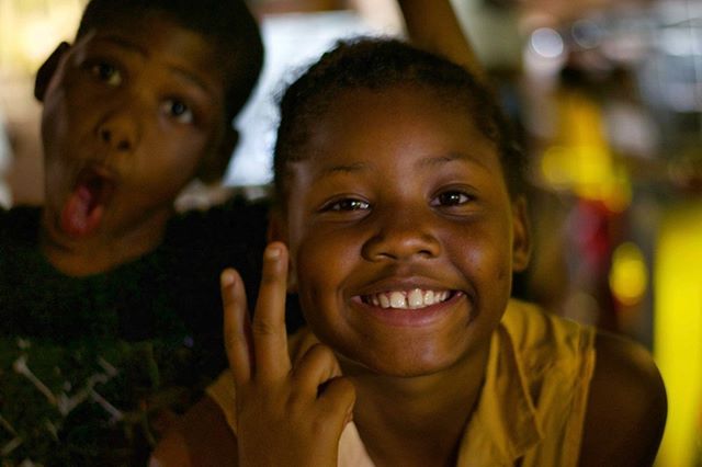 Two smiling kids of african descent pose cheerfully for the camera.