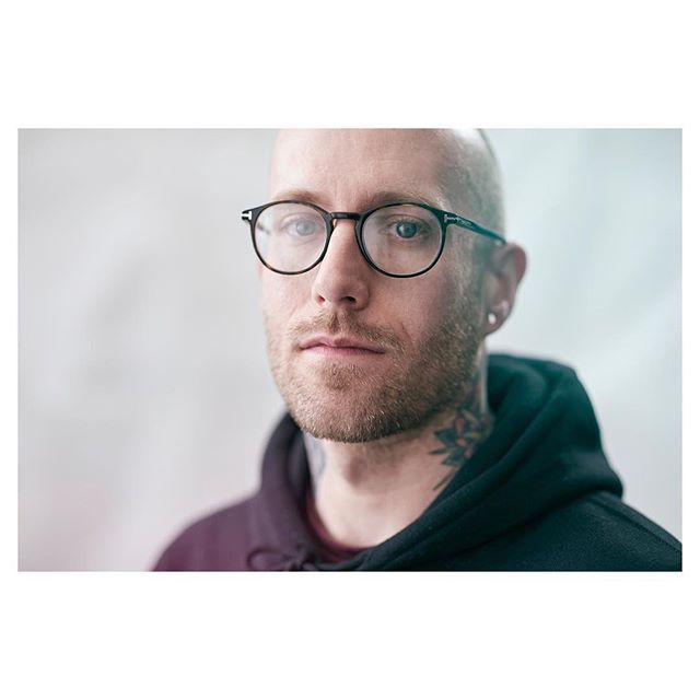 Portrait of a confident man with eyeglasses looking at the camera in a studio setting.