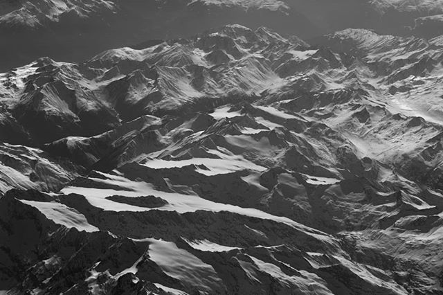 Aerial view of a majestic mountain range covered in snow, creating a serene and awe-inspiring natural landscape.