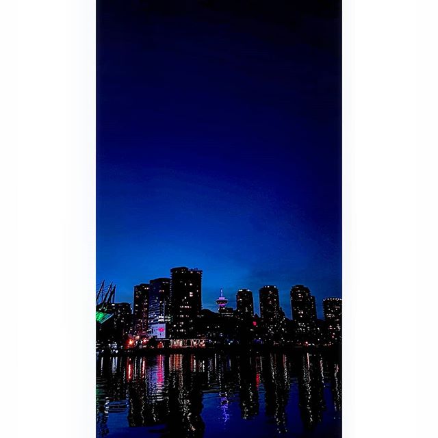 The city skyline reflects off the water in this nighttime urban scene, creating a tranquil atmosphere.