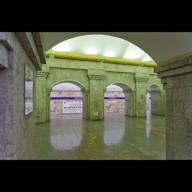 The interior of a subway station featuring arches and pillars creates a serene and architecturally interesting public space.