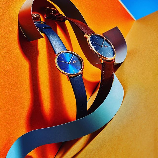 A close-up studio shot features two elegant wristwatches, showcasing their design and craftsmanship.
