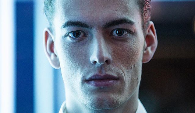 A close-up portrait of a serious man with intense eyes, showcasing a modern and editorial style.