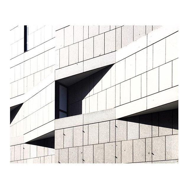 An abstract view of a modern building's facade featuring strong lines and geometric shapes.