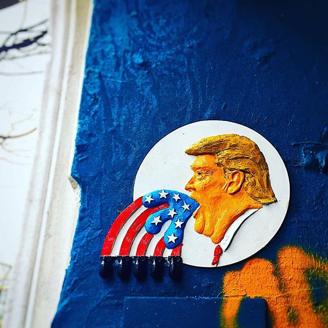 Political street art depicting Donald Trump, with a satirical representation of the American flag.