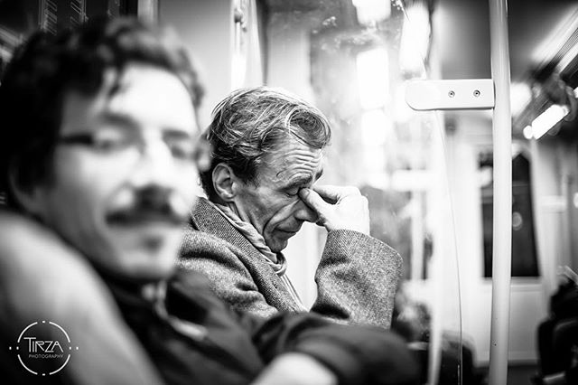 A poignant black and white portrait of a man on a train, conveying emotion and introspection.