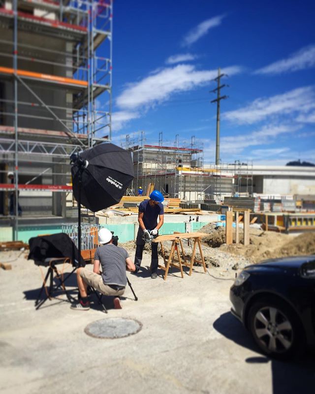 Two construction workers are filmed on a building site on a sunny day.